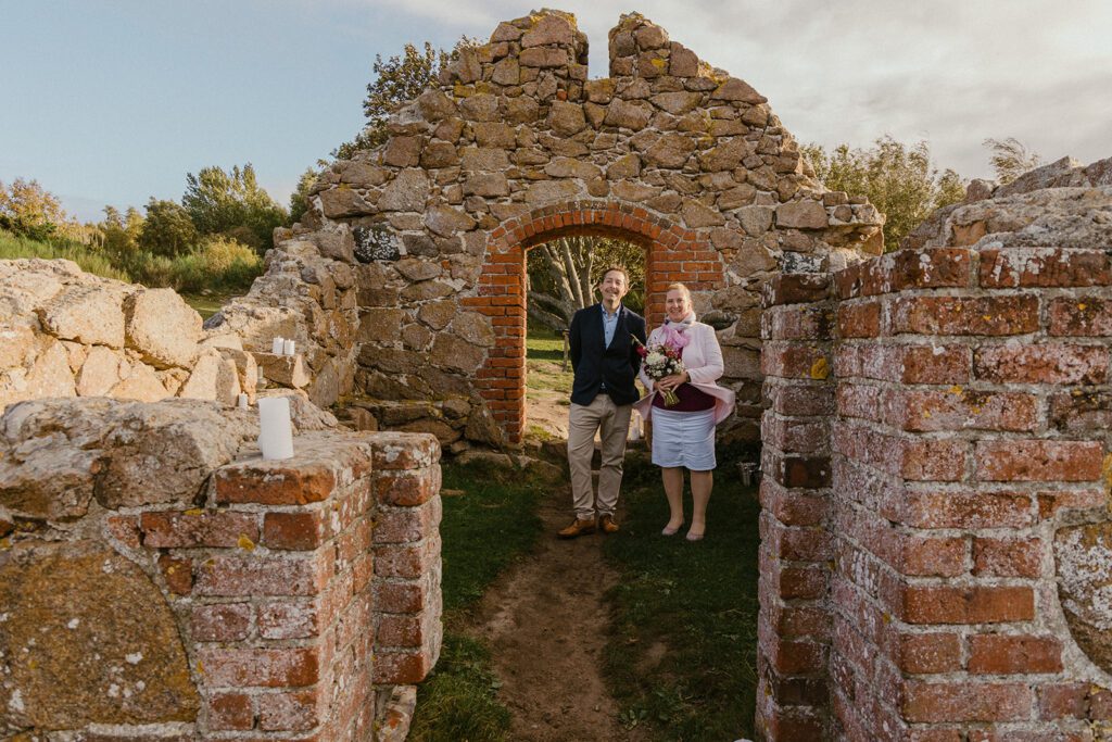 A German couple walks down the aisle through a gate of Salomon's Chapel on Bornholm in Denmark.