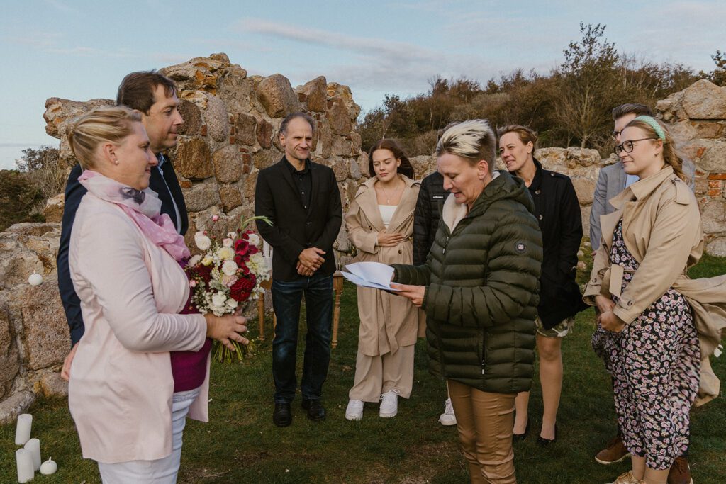 A Danish registrar from the registry office on Bornholm is performing the wedding rites on a historical sites.