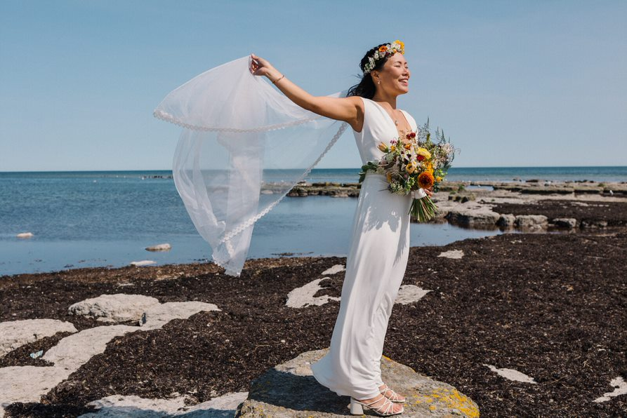 Bride on a rock by the sea in Snogebæk on Bornholm.