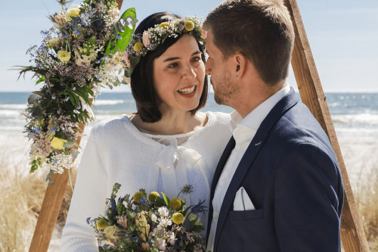 Passende Blumendekoration, Brautstrauß und Hochzeitshaarkranz an einem Strand auf Bornholm.