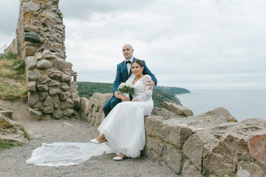 A just wedded couple sitting at the ruins of Hammershus Fortress on Bornholm.