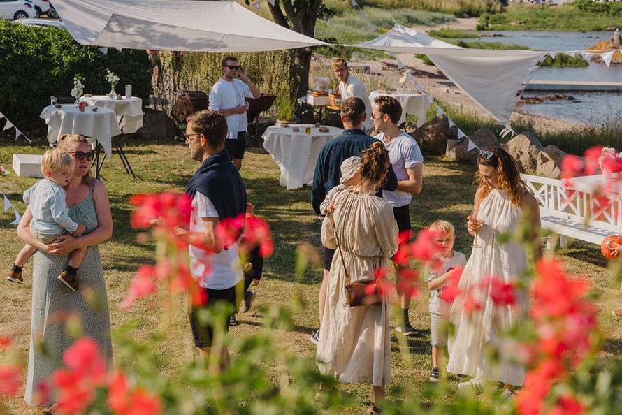 A large wedding party celebrates on the waterfront in Bornholm.