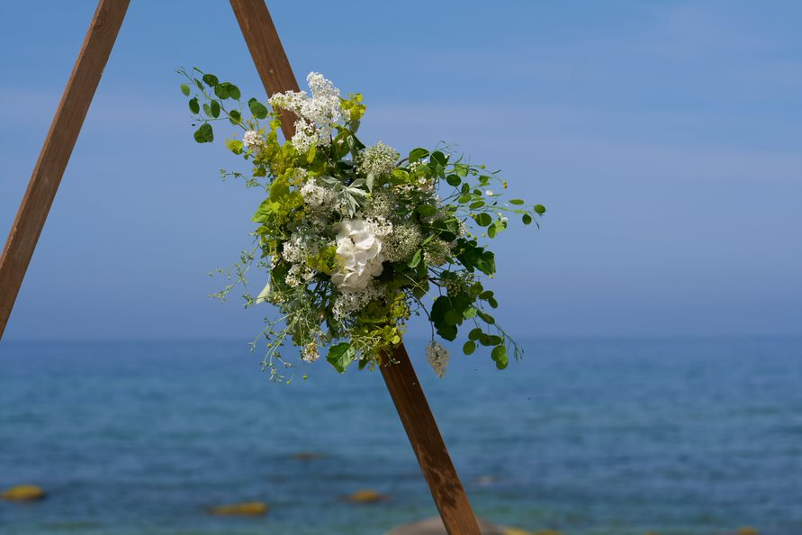 Floral decorations on a wedding gate placed on a beach on Bornholm in Denmark.