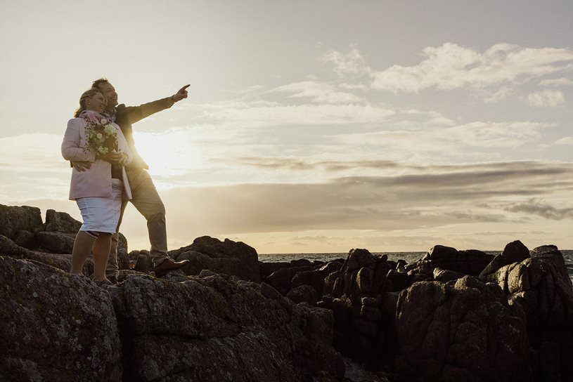 A newly wed German couple enjoys the view from the cliffs in the North of Bornholm in Denmark for their wedding photo.