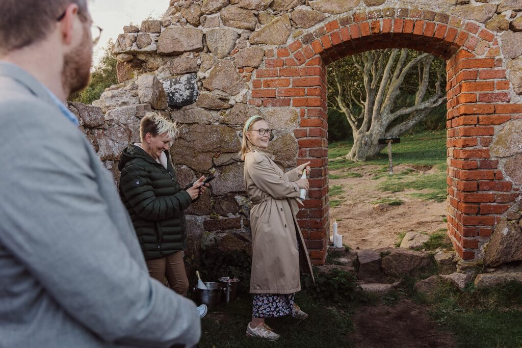 Ein deutsches Paar, das heiraten will, auf dem Gang zu einem natürlichen Altar in den Ruinen der Salomons Kapel auf Bornholm in Dänemark.