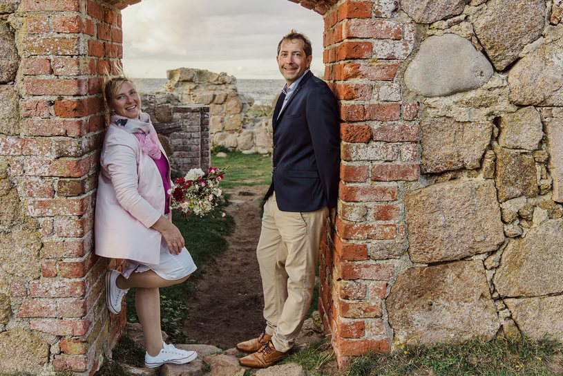 Ein deutsches Hochzeitspaar posiert für den Hochzeitsfotografen in den Ruinen einer historischen Stätte auf Bornholm.