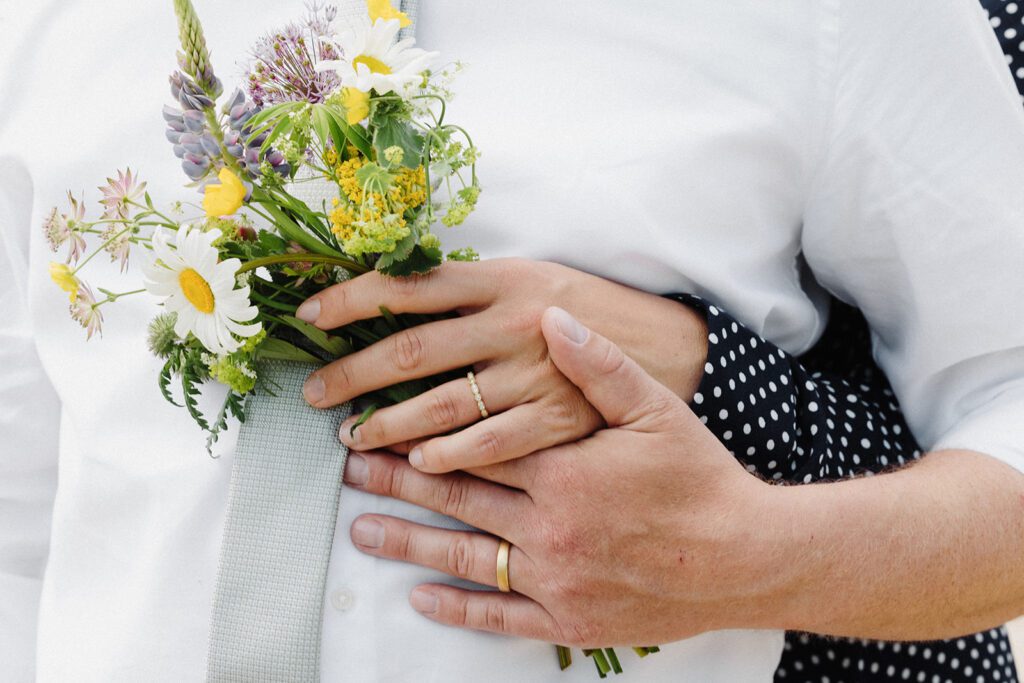 A couple holds on to a wedding bouquet on Bornholm in Denmark.