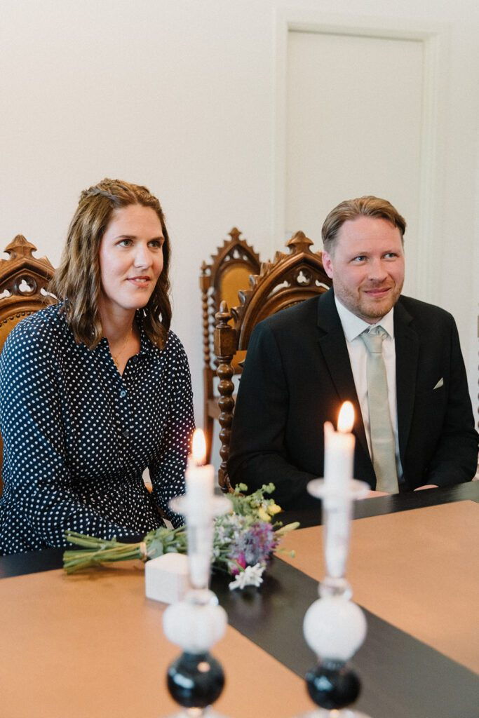 Ein deutsches Paar hört dem dänischen Standesbeamten bei ihrer Standesamt-Blitzhochzeit auf Bornholm zu.