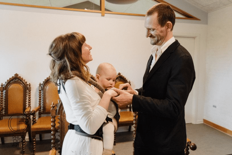 Ein Hochzeitspaar mit Baby auf dem Standesamt in Bornholm in Dänemark.