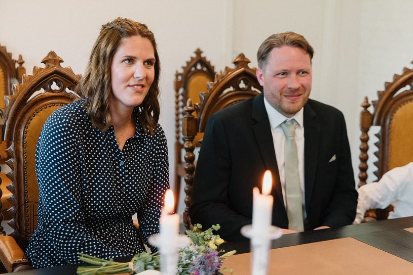 A couple about to be married listens to the Danish registrar at the registry office during elopement wedding on Bornholm.