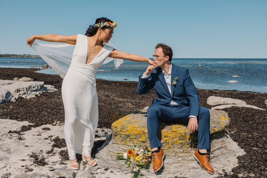 A newly-wed couple sitting on the beach of Snogebæk on Bornholm in Denmark.