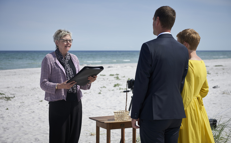 A bridal couple in front of the registrar during a beach wedding on Bornholm.