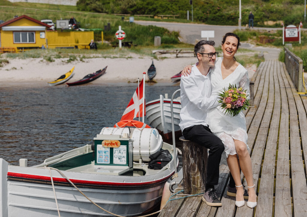 Ein in Dänemark getrautes Paar sitzt in einem Hafen auf Bornholm.