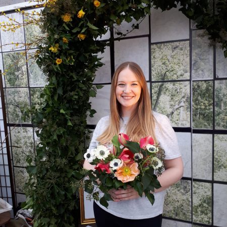 Eine Hochzeitsplanerin in Dänemark hält einen Brautstrauss auf dem Weg zu einer Hochzeit auf Bornholm.